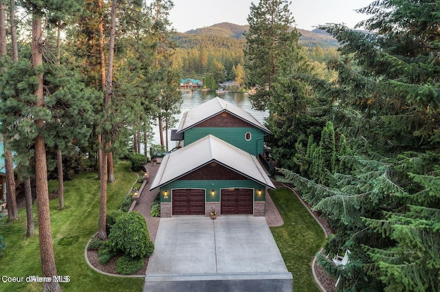 515 S Idaho St, Post Falls, ID 83854 - view of front of house with a forest view, driveway, a front lawn, a garage, and a water view