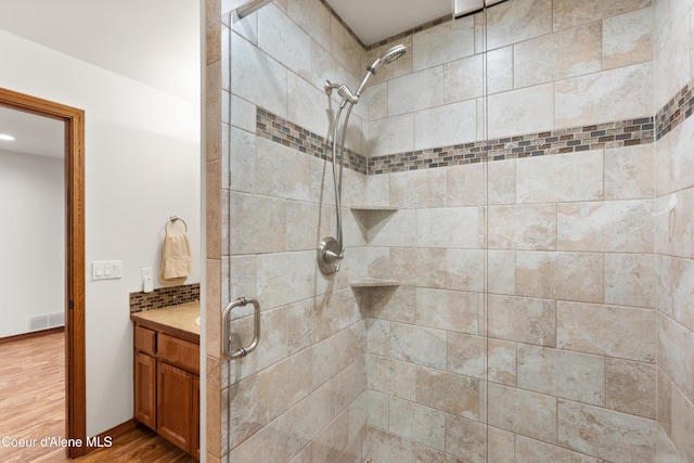 515 S Idaho St, Post Falls, ID 83854 - full bathroom featuring a shower stall, wood finished floors, vanity, and tasteful backsplash