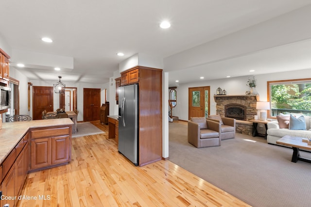 515 S Idaho St, Post Falls, ID 83854 - kitchen with stainless steel appliances, a stone fireplace, light wood-type flooring, recessed lighting, and light countertops