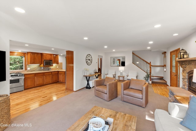 515 S Idaho St, Post Falls, ID 83854 - living room with recessed lighting, stairway, a stone fireplace, light wood-style flooring, and light colored carpet