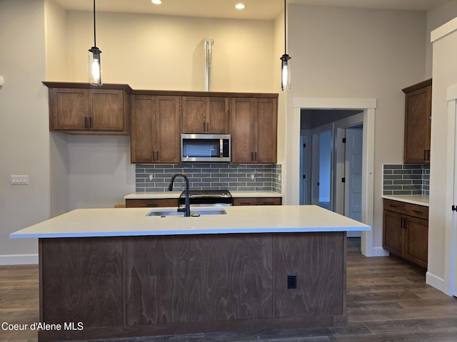 8675 W Hood St, Rathdrum, ID 83858 - kitchen with stainless steel microwave, tasteful backsplash, recessed lighting, dark wood-style floors, and light countertops