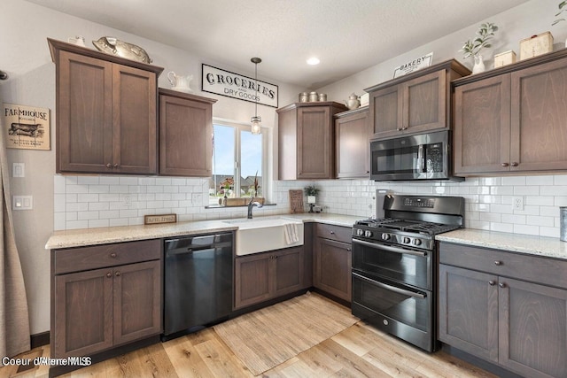 1546 N Tatum Dr, Post Falls, ID 83854 - kitchen with dishwashing machine, stainless steel microwave, range with gas stovetop, and tasteful backsplash