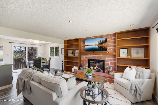 1024 W Mill Ave, Coeur Dalene, ID 83814 - living area with a textured ceiling, wood finished floors, a brick fireplace, built in shelves, and recessed lighting