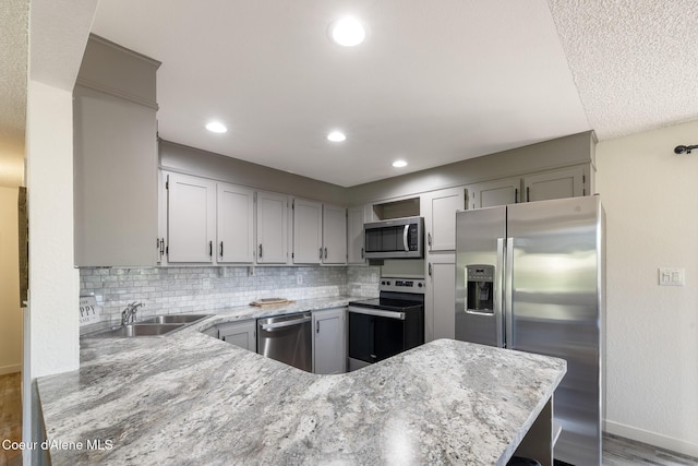 1024 W Mill Ave, Coeur Dalene, ID 83814 - kitchen with appliances with stainless steel finishes, a peninsula, backsplash, wood finished floors, and recessed lighting