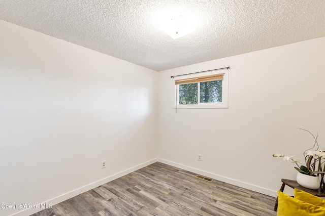 1024 W Mill Ave, Coeur Dalene, ID 83814 - empty room featuring wood finished floors and a textured ceiling
