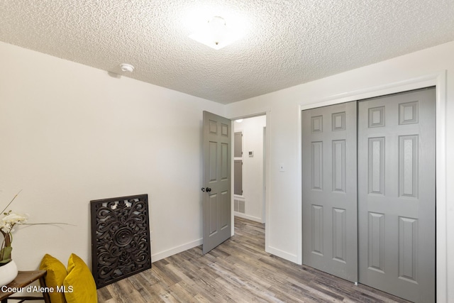 1024 W Mill Ave, Coeur Dalene, ID 83814 - bedroom with a textured ceiling, wood finished floors, and a closet