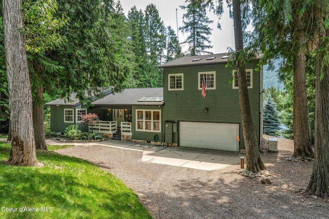 512 River Dr, Clark Fork, ID 83811 - split level home with dirt driveway, an attached garage, and a porch
