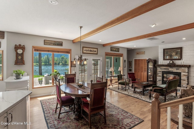 512 River Dr, Clark Fork, ID 83811 - dining area featuring beamed ceiling, light wood-type flooring, a fireplace, recessed lighting, and a water view