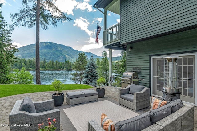 512 River Dr, Clark Fork, ID 83811 - patio / terrace with an outdoor hangout area, a grill, a water and mountain view, a patio area, and a yard