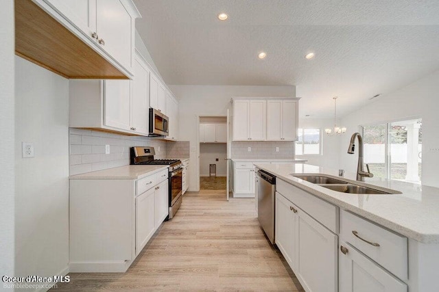 4300 N Arrowleaf Loop, Post Falls, ID 83854 - kitchen featuring appliances with stainless steel finishes, light wood-type flooring, tasteful backsplash, white cabinetry, and recessed lighting