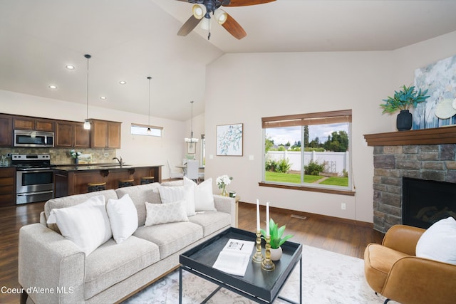 10955 N Seaside St, Hayden, ID 83835 - living room featuring a ceiling fan, dark wood-style floors, high vaulted ceiling, a fireplace, and recessed lighting