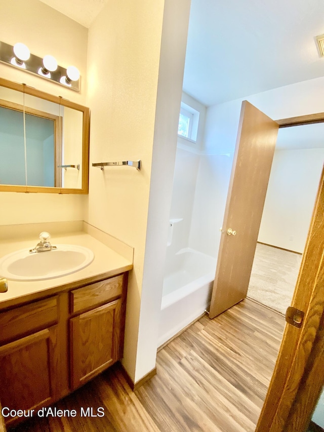 3674 E 2nd Ave, Post Falls, ID 83854 - bathroom featuring wood finished floors, vanity, and shower / washtub combination