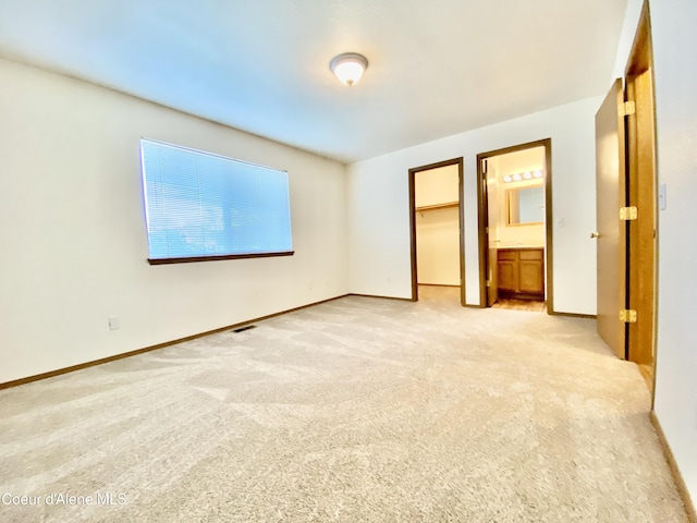 3674 E 2nd Ave, Post Falls, ID 83854 - unfurnished bedroom with light carpet, a walk in closet, and a closet