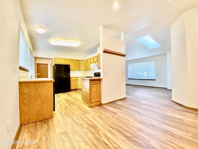 3674 E 2nd Ave, Post Falls, ID 83854 - kitchen featuring a skylight, black appliances, light wood-type flooring, light countertops, and under cabinet range hood