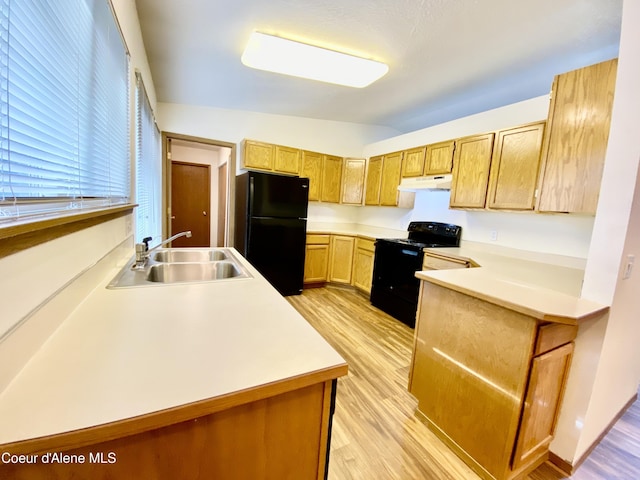3674 E 2nd Ave, Post Falls, ID 83854 - kitchen with black appliances, under cabinet range hood, a peninsula, and light wood-style floors