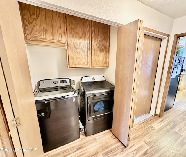 3674 E 2nd Ave, Post Falls, ID 83854 - laundry area with cabinet space, light wood-style flooring, and washer and clothes dryer