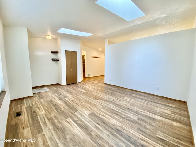 3674 E 2nd Ave, Post Falls, ID 83854 - unfurnished room featuring a skylight, light wood-style flooring, and lofted ceiling