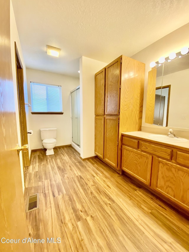 3674 E 2nd Ave, Post Falls, ID 83854 - full bath with wood finished floors, vanity, a shower stall, and a textured ceiling
