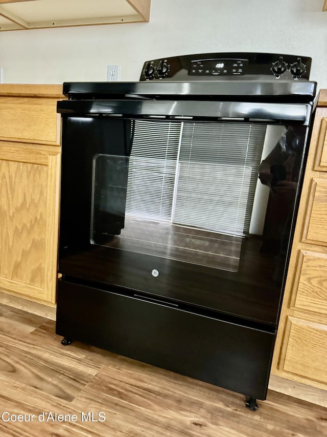 3674 E 2nd Ave, Post Falls, ID 83854 - kitchen view of black electric range oven, light brown cabinetry, and light wood-style floors