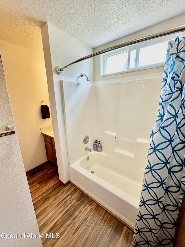 3674 E 2nd Ave, Post Falls, ID 83854 - bathroom with wood finished floors, shower / tub combo with curtain, a textured ceiling, and vanity