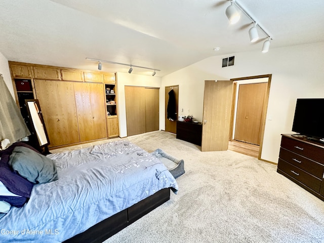 3674 E 2nd Ave, Post Falls, ID 83854 - bedroom featuring rail lighting, light colored carpet, and two closets
