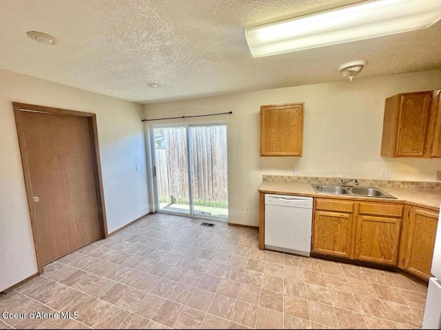 3674 E 2nd Ave, Post Falls, ID 83854 - kitchen featuring white dishwasher, light countertops, a textured ceiling, and brown cabinetry