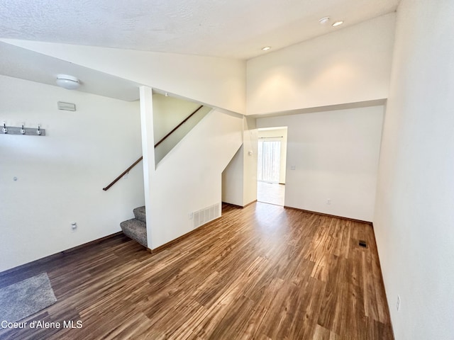 3674 E 2nd Ave, Post Falls, ID 83854 - unfurnished living room with vaulted ceiling, wood finished floors, stairs, and recessed lighting
