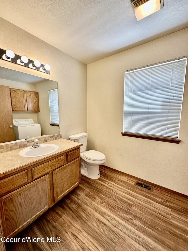 3674 E 2nd Ave, Post Falls, ID 83854 - bathroom with washing machine and dryer, wood finished floors, and vanity