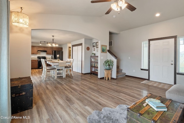 6595 W Covenant St, Rathdrum, ID 83858 - living area with arched walkways, light wood-type flooring, stairs, ceiling fan, and lofted ceiling