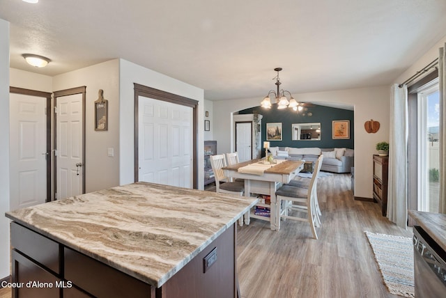 6595 W Covenant St, Rathdrum, ID 83858 - kitchen with light wood-type flooring, stainless steel dishwasher, light stone countertops, a chandelier, and hanging light fixtures