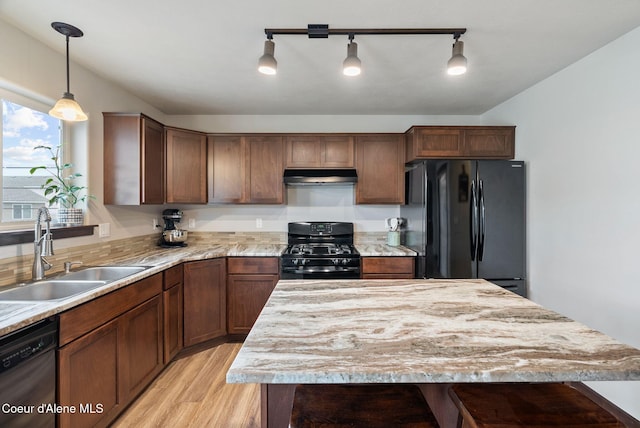 6595 W Covenant St, Rathdrum, ID 83858 - kitchen with black appliances, under cabinet range hood, light wood finished floors, decorative light fixtures, and a center island