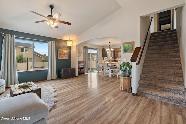 6595 W Covenant St, Rathdrum, ID 83858 - living area with arched walkways, stairway, vaulted ceiling, a chandelier, and ceiling fan