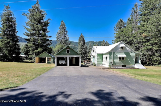 67 Nuchols Gulch Rd, Osburn, ID 83849 - view of front of house featuring a garage, an outdoor structure, a front yard, and a mountain view