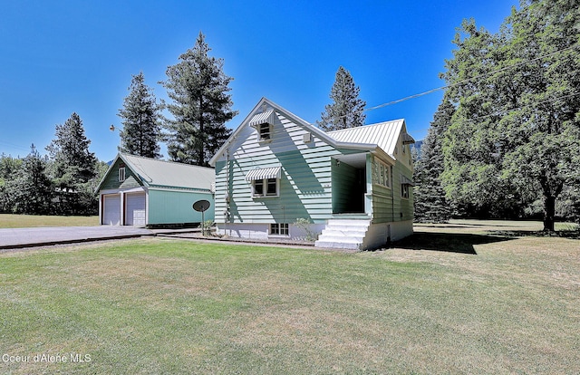 67 Nuchols Gulch Rd, Osburn, ID 83849 - view of front of house featuring a detached garage, a front lawn, an outbuilding, and a metal roof
