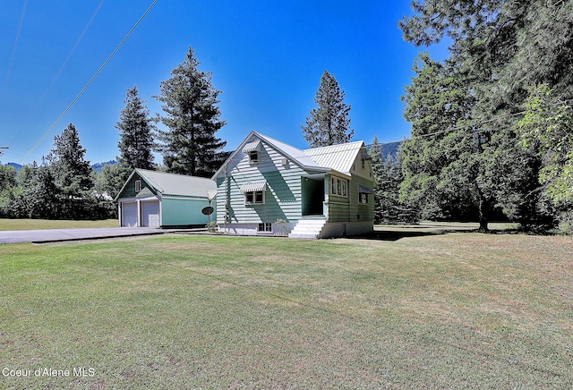 67 Nuchols Gulch Rd, Osburn, ID 83849 - view of side of home featuring an outdoor structure, a yard, a detached garage, a metal roof, and driveway