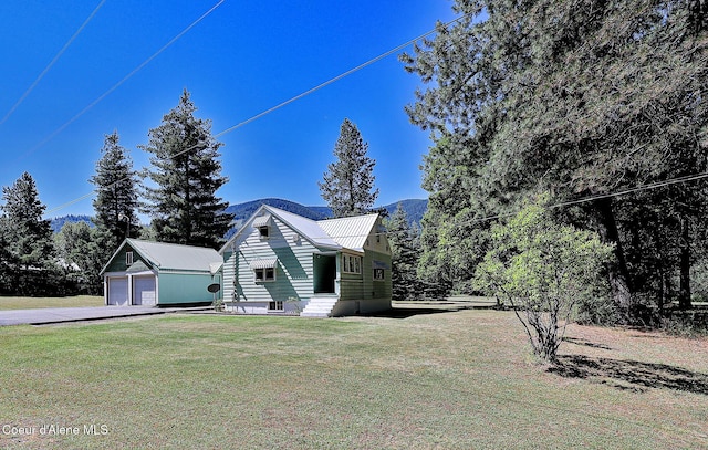 67 Nuchols Gulch Rd, Osburn, ID 83849 - view of side of home featuring an outbuilding, a yard, a garage, a metal roof, and driveway