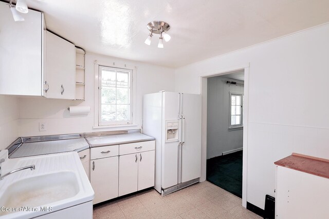 67 Nuchols Gulch Rd, Osburn, ID 83849 - kitchen with white fridge with ice dispenser, light flooring, plenty of natural light, and white cabinets