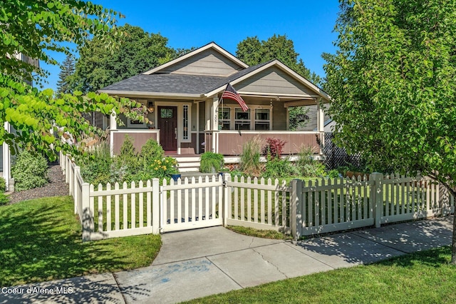 307 S 18th St, Coeur Dalene, ID 83814 - bungalow-style home featuring covered porch, a fenced front yard, a shingled roof, and a gate