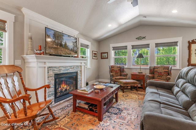 307 S 18th St, Coeur Dalene, ID 83814 - living room featuring lofted ceiling, plenty of natural light, ceiling fan, a stone fireplace, and a textured ceiling