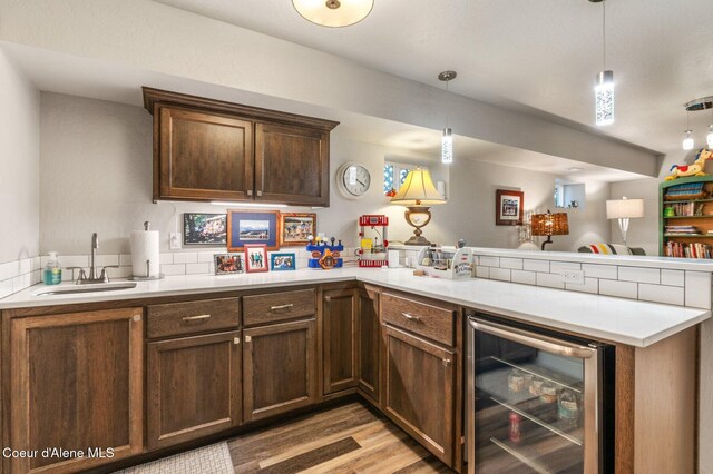307 S 18th St, Coeur Dalene, ID 83814 - kitchen featuring wine cooler, a peninsula, light countertops, light wood finished floors, and pendant lighting