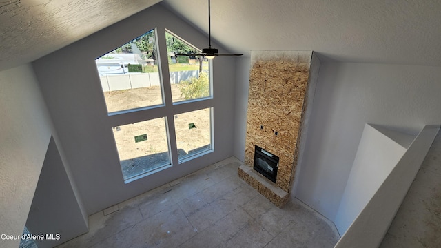 2003 E Plaza Ct, Post Falls, ID 83854 - unfurnished living room featuring a textured ceiling, vaulted ceiling, and a fireplace
