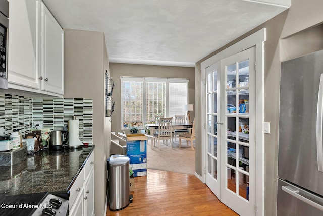 959 N Rutledge Ct, Coeur Dalene, ID 83814 - kitchen with freestanding refrigerator, white cabinets, light wood-style flooring, stove, and backsplash