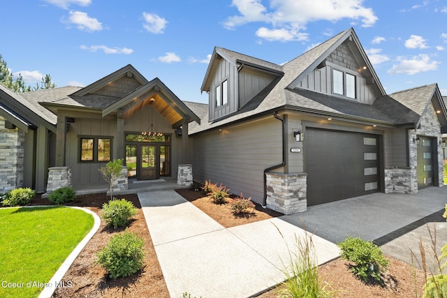 11551 N Bluejay Loop, Hayden, ID 83835 - view of front of house with board and batten siding, stone siding, roof with shingles, driveway, and a garage