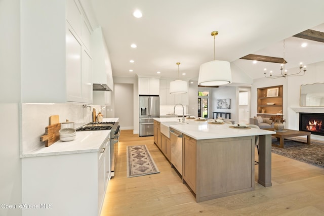 11551 N Bluejay Loop, Hayden, ID 83835 - kitchen featuring stainless steel appliances, light wood finished floors, decorative backsplash, a kitchen breakfast bar, and recessed lighting
