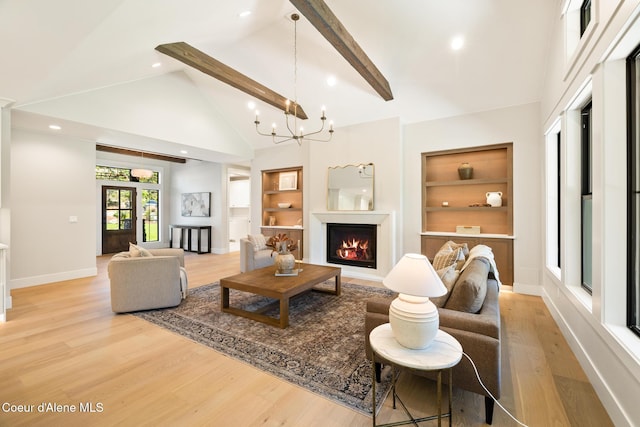 11551 N Bluejay Loop, Hayden, ID 83835 - living area with built in features, high vaulted ceiling, light wood-style flooring, beam ceiling, and a chandelier