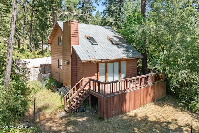14545 N Samhill Trl, Hayden, ID 83835 - rear view of house with a wooden deck, stairs, a chimney, and a metal roof