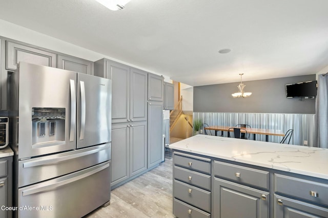 3206 N Lodgepole Rd, Coeur Dalene, ID 83815 - kitchen with stainless steel refrigerator with ice dispenser, gray cabinetry, light wood-style flooring, a chandelier, and pendant lighting
