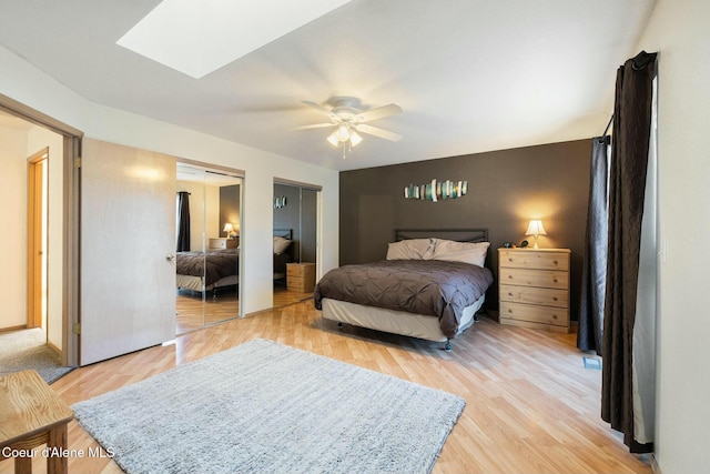 3206 N Lodgepole Rd, Coeur Dalene, ID 83815 - bedroom featuring multiple closets, light wood-style flooring, a skylight, and a ceiling fan