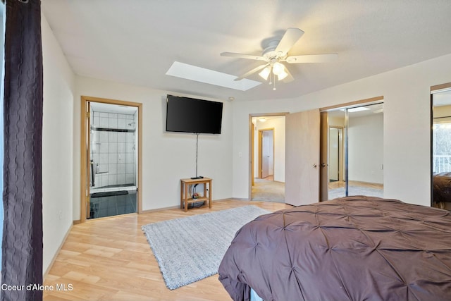 3206 N Lodgepole Rd, Coeur Dalene, ID 83815 - bedroom featuring a skylight, light wood-style flooring, two closets, ensuite bath, and ceiling fan