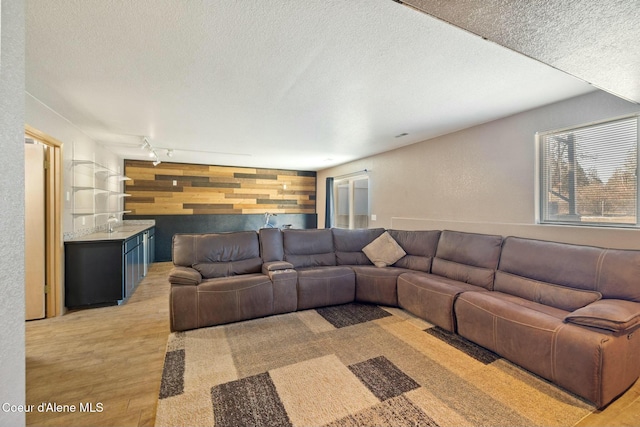 3206 N Lodgepole Rd, Coeur Dalene, ID 83815 - living area with wood walls, a textured ceiling, bar, light wood-type flooring, and rail lighting